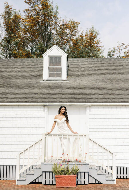 Bride standing at a balcony in frontof a historic home