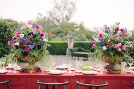 Reception table decorated with floral urns in the garden of Parker Ranch