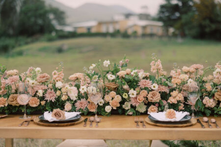 Floralscape on a reception table in front of a historic home at Parker Ranch
